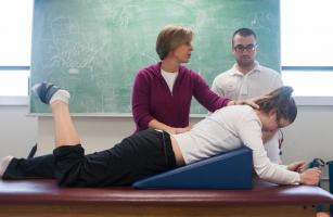 Ellen Anderson, associate professor of physical therapy, demonstrates on a student